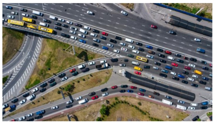 Aerial photograph of congestion at on-ramp, along frontage roads, and in the main lanes of an interstate.