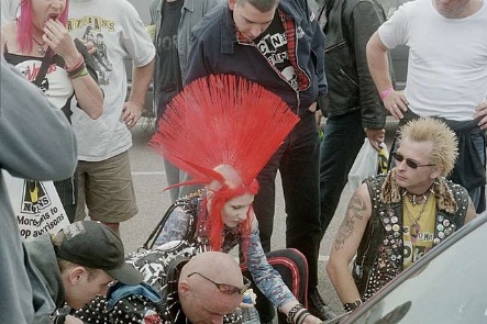 People hanging out, one with a big red mohawk