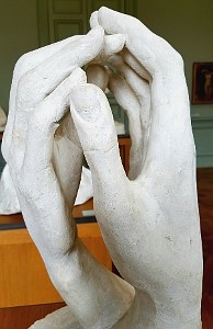 A sculpture of two hands, one masculine, one feminine, held one in another