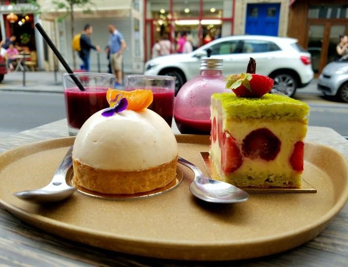 A vanilla cream-covered pastry and a strawberry-pistachio covered cream pastry