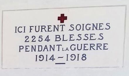 Sign that reads "Ici furent soigné 2254 blessés pendant la guerre 1914-1918" (Here 2254 wounded were treated during the war 1914-1918)