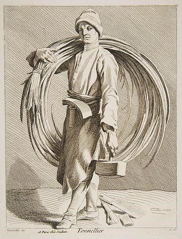 A cooper carrying materials for barrel making