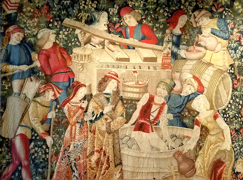 medieval tapestry showing various stages of wine-making, including a man stomping on grapes in a vat