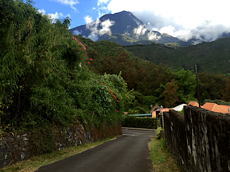 A mountain peak towers above a tropical scene