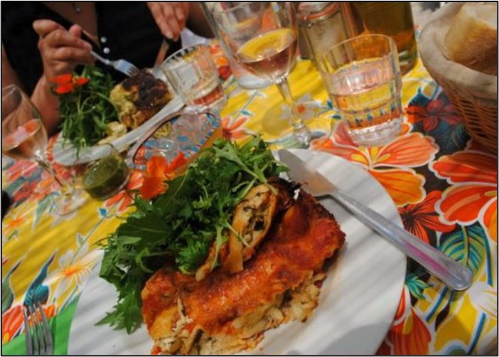 Glasses of rosé wine placed on a table next to plates of food