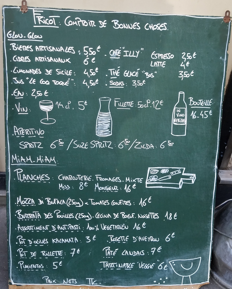 Chalkboard menu featuring drinks such as "bières artisinales," "cidres artisanaux," "limonades de Sicile," "café Illy," "thé glacé," "eau," and "vin."