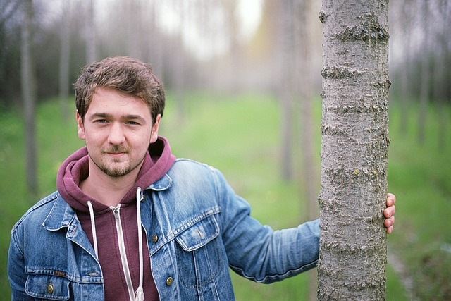 Young man with mustache in wooded area