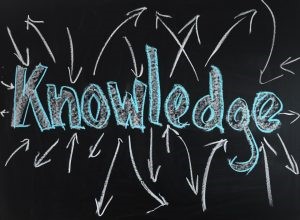 the word knowledge is written in blue and white chalk on a black background with white arrows going in different directions